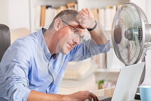 Man suffers from heat in the office or at home