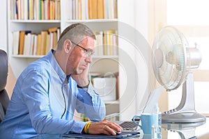 Man suffers from heat in the office or at home