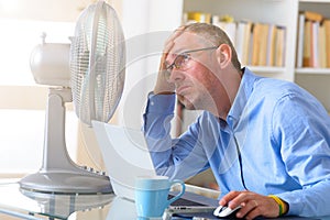 Man suffers from heat in the office or at home