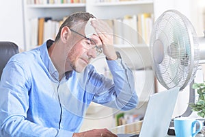 Man suffers from heat in the office or at home