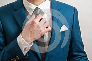 Man in suit adjusting necktie