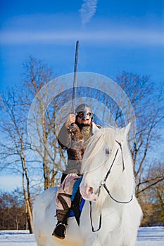 Man in suit of ancient warrior raising his sword