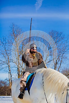 Man in suit of ancient warrior raising his sword