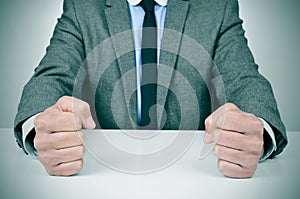 Man in suit banging his fists on a desk photo