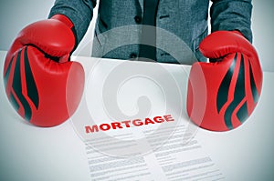 Man in suit with boxing gloves and a mortgage contract