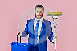 Man in suit with broom and bucket. Funny businessman with happy smiling face holding broom in suit, pure business man