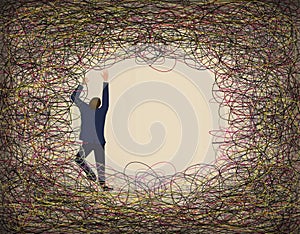 A man in a suit climbs and struggles against a tangle of colored lines of wire