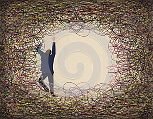A man in a suit climbs and struggles against a tangle of colored lines of wire