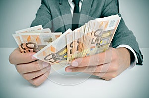 Man in suit with counting euro bills