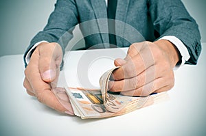 Man in suit counting euro bills