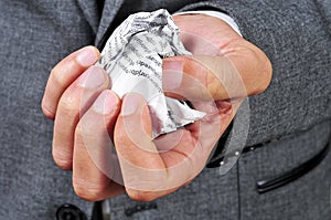 Man in suit with a crumpled piece of paper