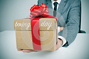 Man in suit with a gift with the text boxing day