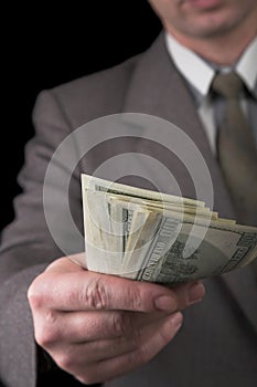 Man in suit giving dollars