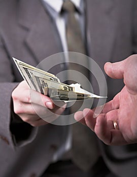 Man in suit giving dollars