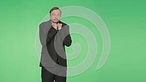 Man in a suit on a green background. body language. fright. hromakey