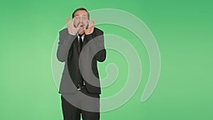 Man in a suit on a green background. body language. fright. hromakey