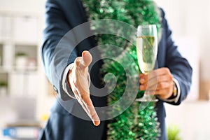 Man in suit hold champagne goblet give arm as hello