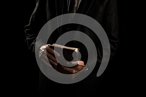 Man in suit holding a bible in his arm on a black background. AI generated