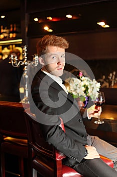 Man in suit holding a glass of wine