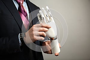 Man in suit holding prosthesis artificial man`s hands