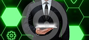 Man in suit holding tablet with one hand. Glow going from device presenting important information. Futuristic digital