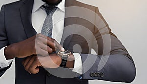 A man in a suit looks at the time at his wristwatch.