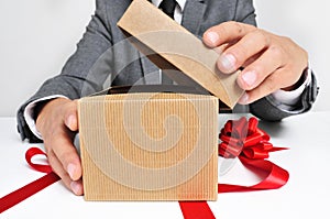 Man in suit opening a gift