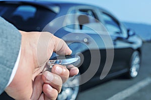 Man in suit opening his car with the control remote key