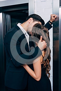 man in suit passionately kissing and