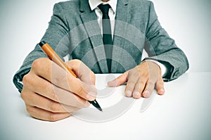 Man in suit with a pen in his hand ready to write