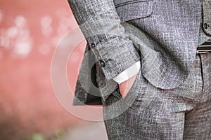 A man in a suit put his hand in his pocket