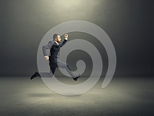 Man in suit running fast in the dark room