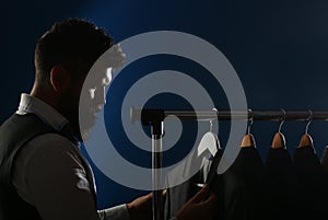 Man in suit. Shirts and suits in a male luxury store. Row of man suit jackets on hangers. Tailor in his workshop