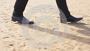 A man in a suit and shoes rides along the beach