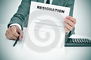 Man in suit showing a figured signed resignation document