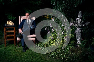 Man in Suit Sitting on Chair in Lush Garden