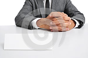 Man in suit sitting in a desk with a blank signboard in front of