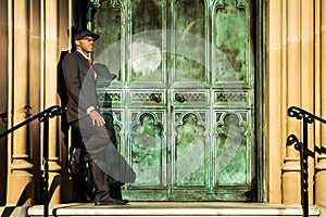 Man in suit standing in front of old doors