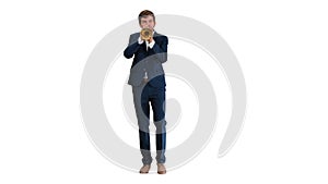 Man in suit standing playing trumpet on white background.