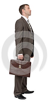 Man in suit with suitcase, side view