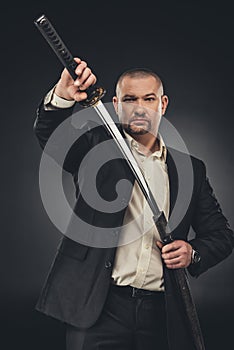 man in suit taking of his katana sword