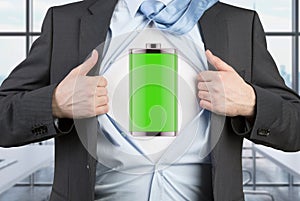 A man in a suit is tearing the blue shirt. Full charged battery on the chest.