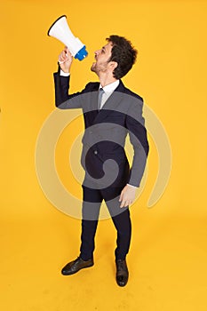 A man in a suit with a tie Handsome looking face with beard In the business man look Holding a megaphone To announce news or