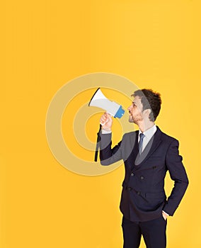 A man in a suit with a tie Handsome looking face with beard In the businessman look Holding a megaphone To announce news. There is