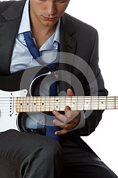 Man in suit and tie playing electric guitar