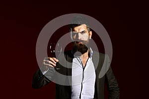 Man in suit toasting with sparkling glass of red wine