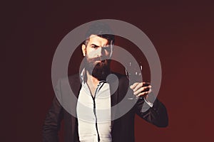 Man in suit toasting with sparkling glass of red wine