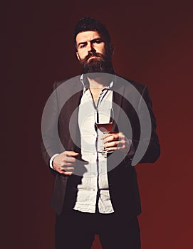 Man in suit toasting with sparkling glass of red wine