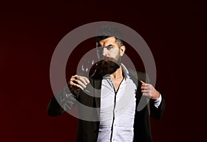 Man in suit toasting with sparkling glass of red wine