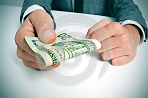 Man in suit with a wad of american dollar bills